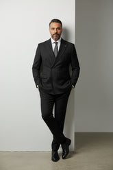 Man wearing black pinstripe double-breasted suit with tailored fit and elegant design.